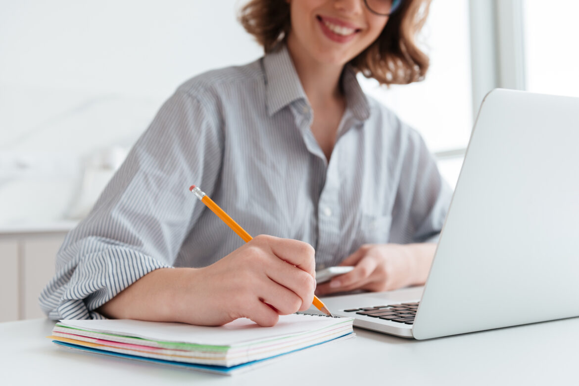 Cropped photo of young smiling woman in striped shirt taking not