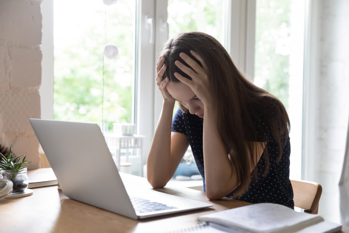 Unhappy,Hopeless,Woman,Clasping,Her,Head,,Sit,At,Desk,With