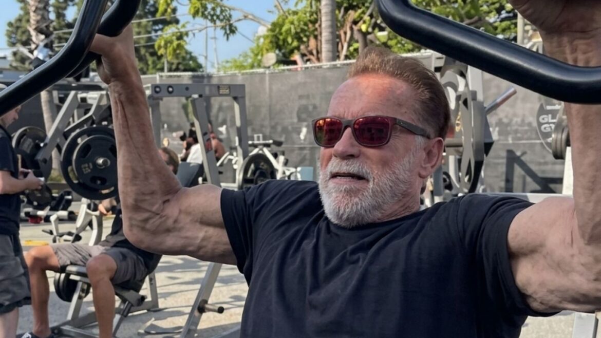 Arnold Schwarzenegger levantando pesas durante su entrenamiento mientras celebra sus 79 años.