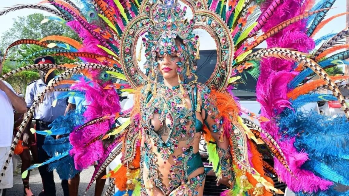 Rihanna luciendo un traje turquesa con plumas y cristales durante el festival Crop Over 2026 en Barbados.