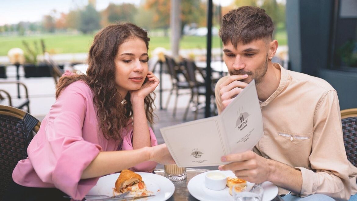 Pareja revisando sus gastos y cuentas mientras conversa sobre cómo repartir sus responsabilidades económicas.