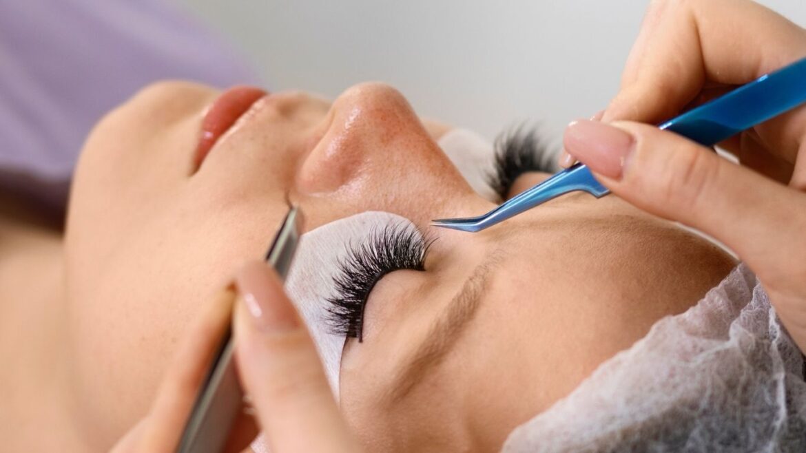 Mujer durante un procedimiento de lifting o extensión de pestañas en un salón de belleza.
