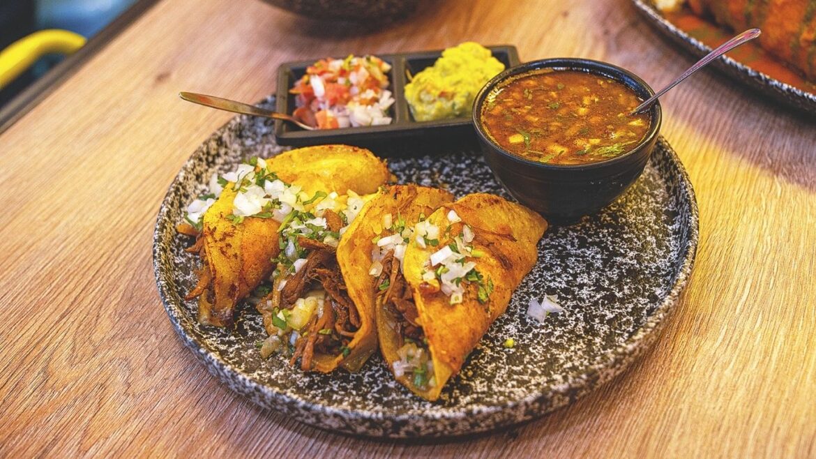 Tacos de birria con queso, guacamole, pico de gallo y consomé de Mandil.